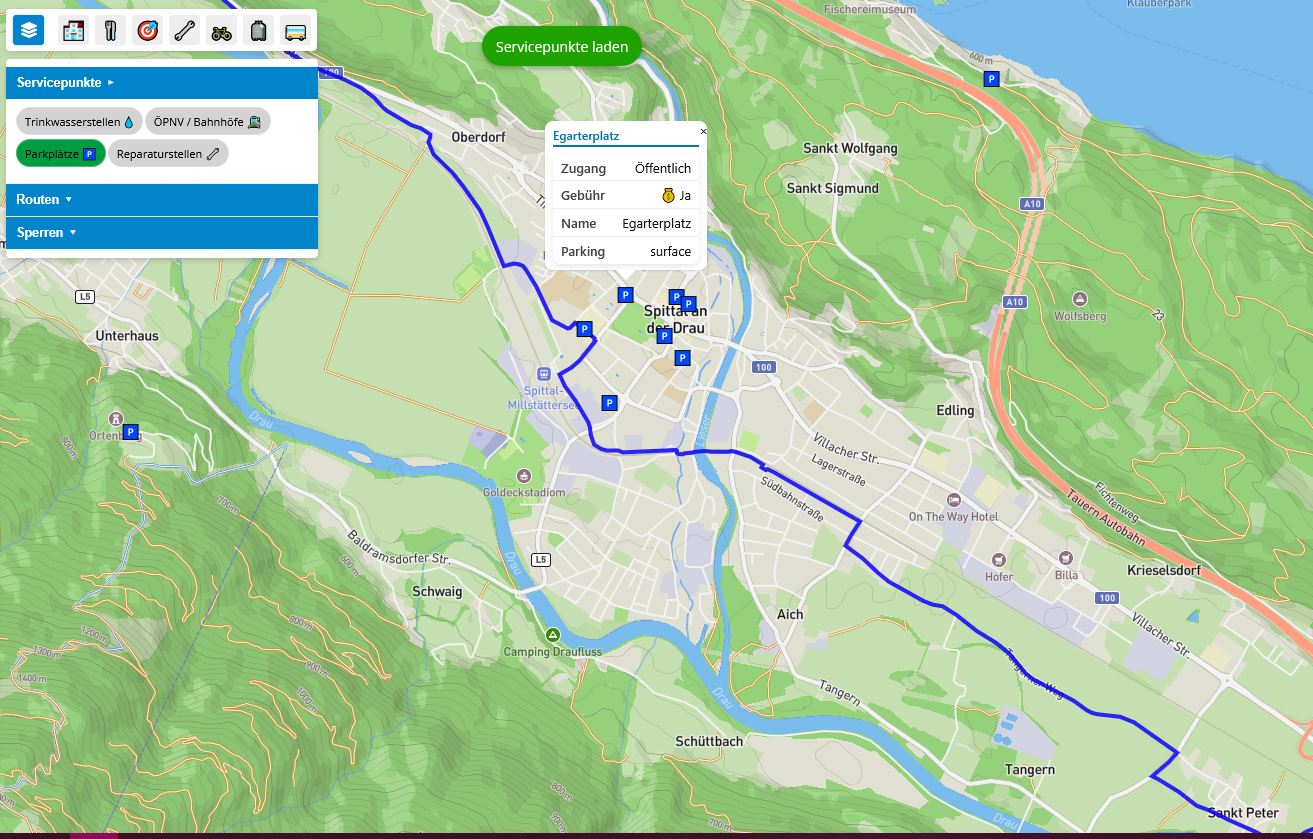 Karte der Drauradwegwirte mit dem Fokus auf Spittal an der Drau mit hervorgehobener Radroute und markierten Servicepunkten wie Parkplätzen.